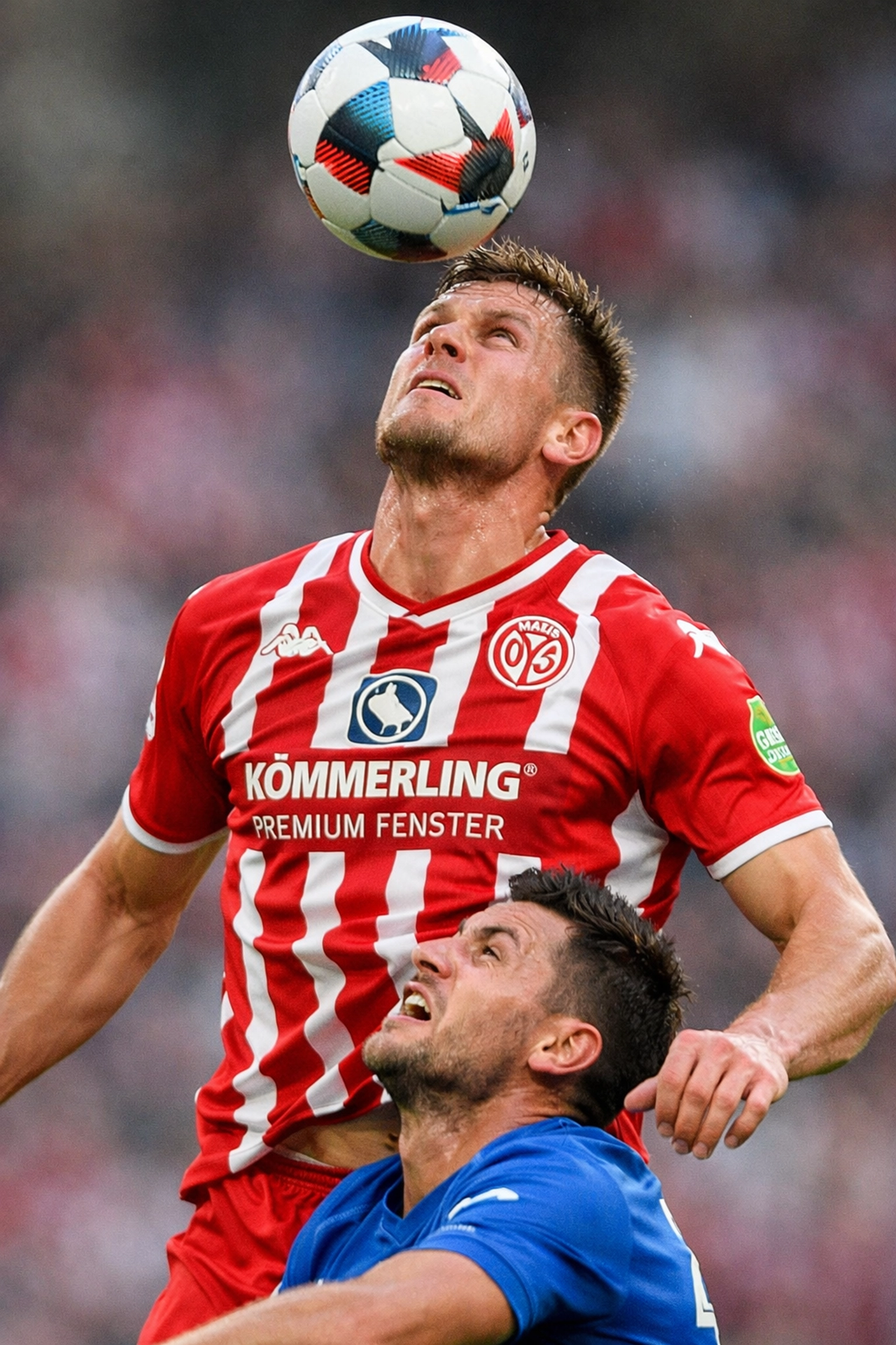 Mainz 05 Stürmer gewinnt Kopfballduell im Bundesliga-Spiel gegen gegnerischen Verteidiger