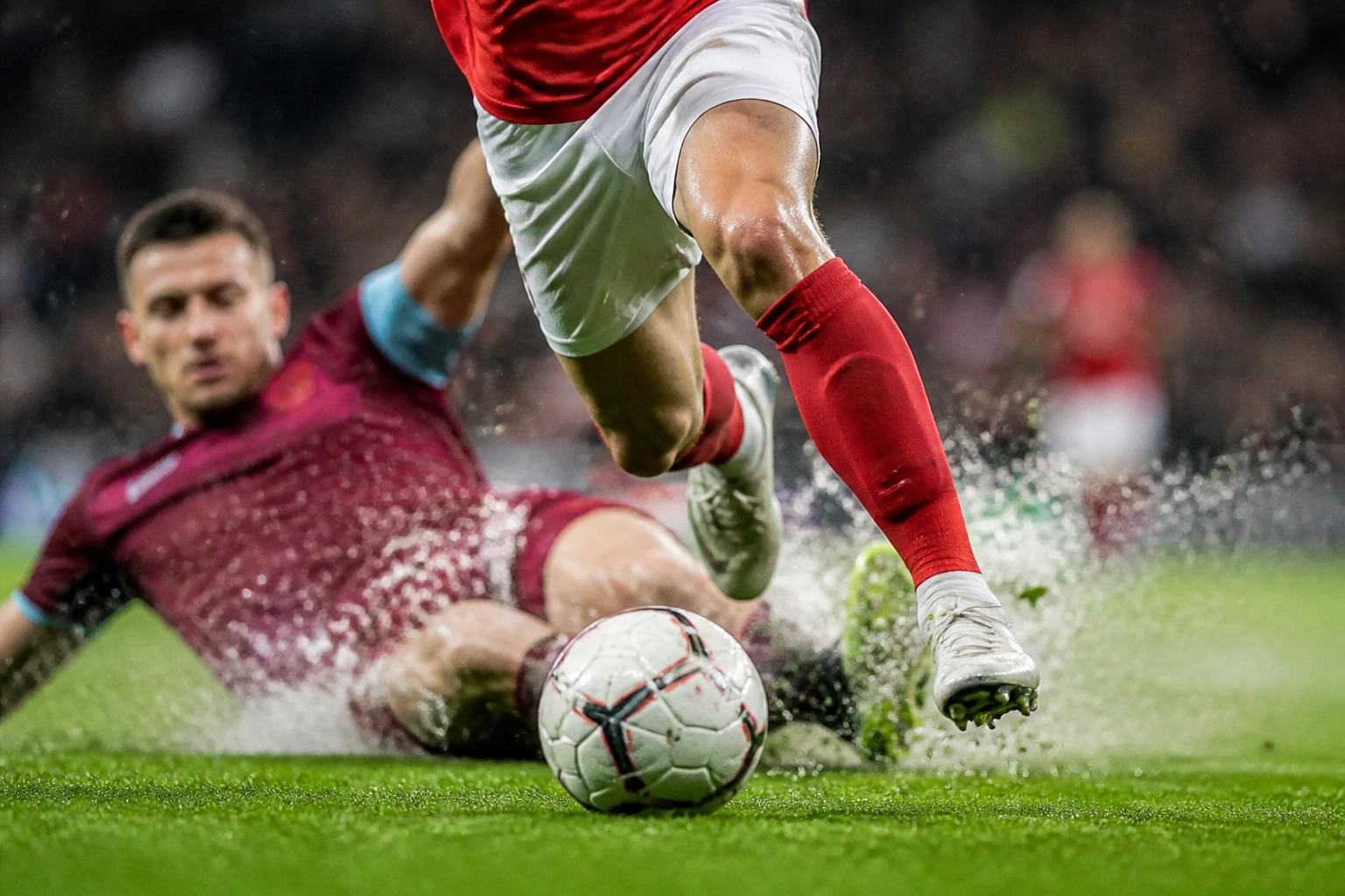 Intensiver Zweikampf im London Derby zwischen West Ham und Arsenal Spielern auf dem Rasen.