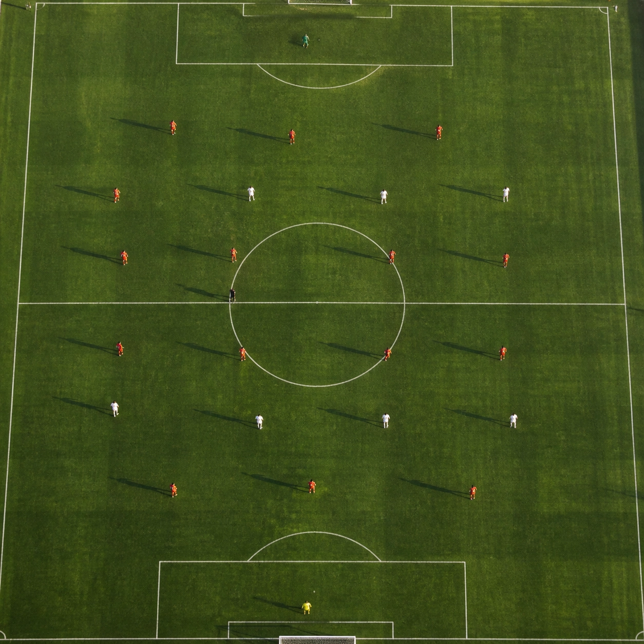 Taktische Analyse einer Box-Mittelfeld-Formation auf dem Fußballfeld aus der Vogelperspektive.