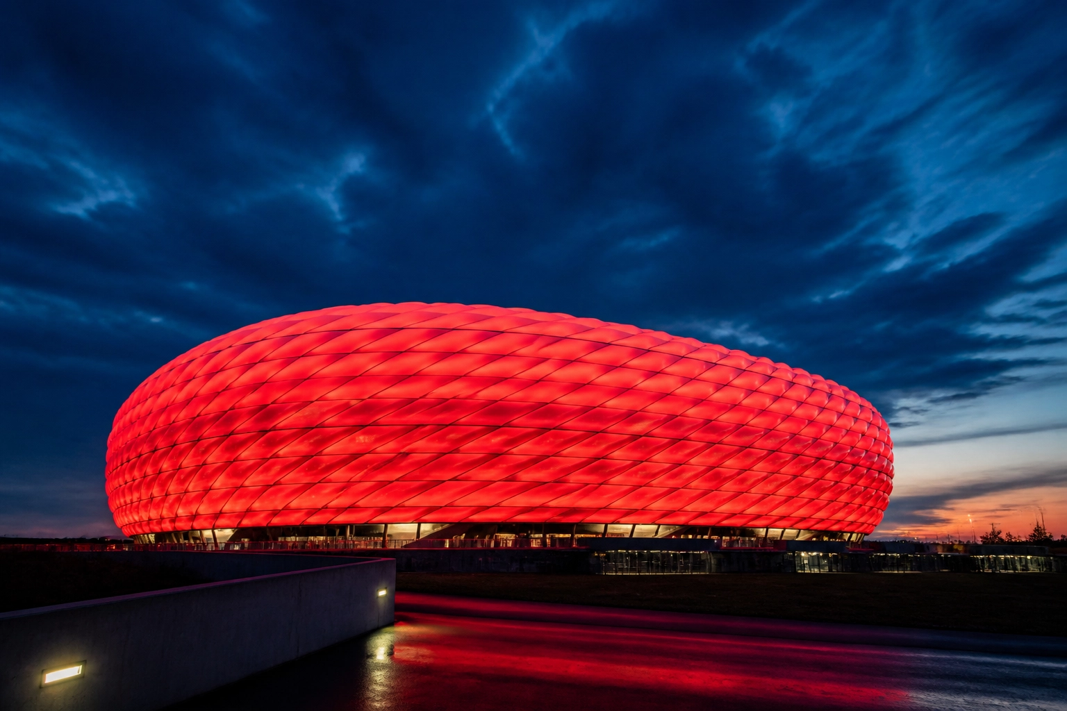 Die rot leuchtende Allianz Arena in München vor dem Champions League Spiel Bayern gegen PSG.