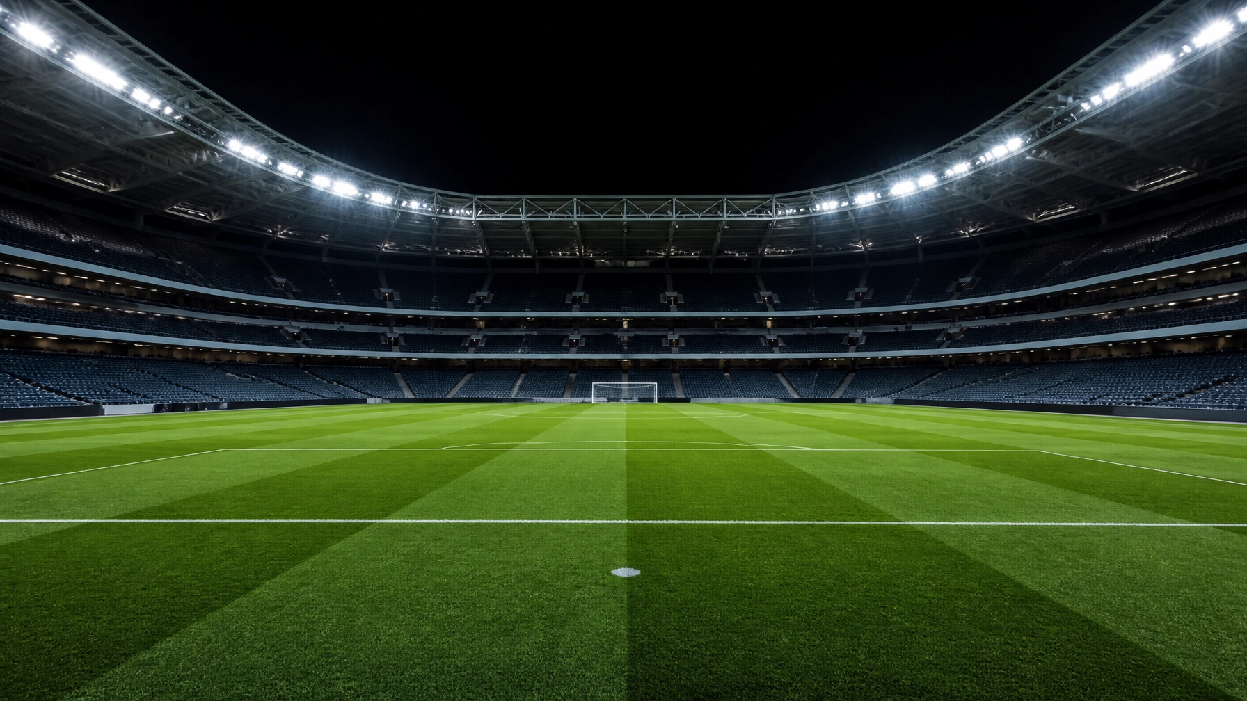 Ein leeres Fußballstadion bei Nacht unter Flutlicht als Symbol für die Arena der Strategie