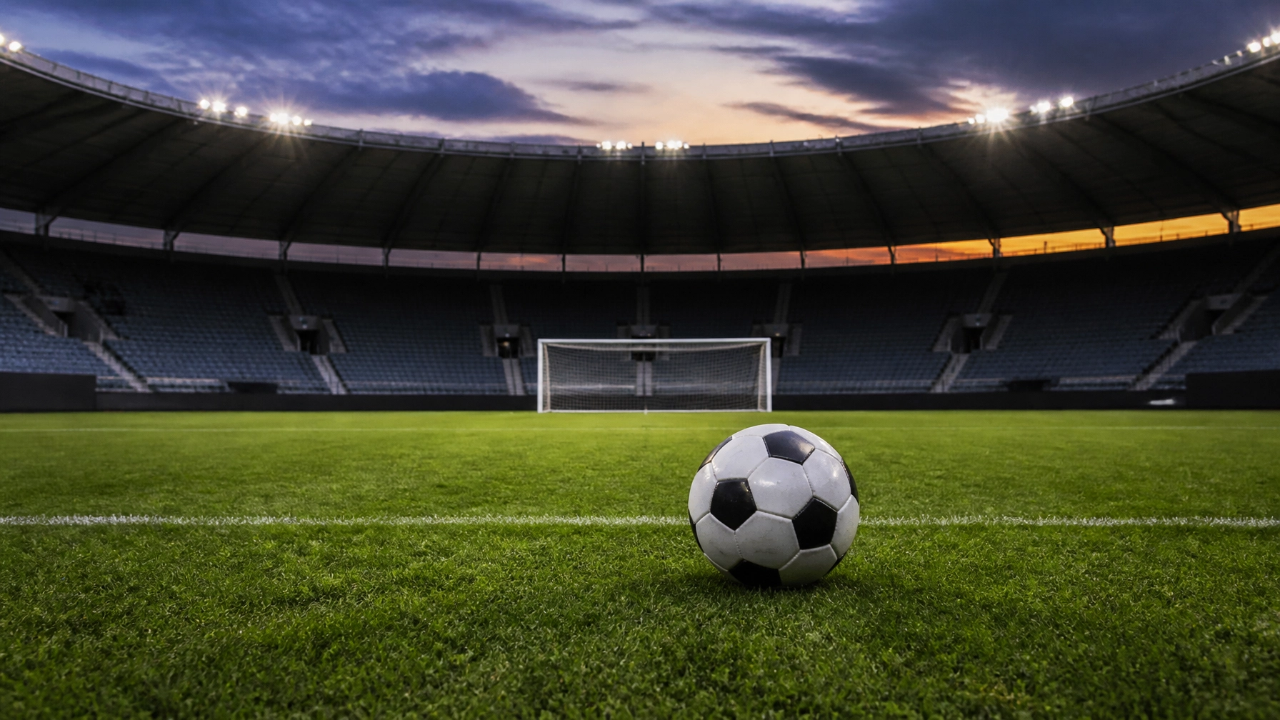 Neutraler Fußball auf dem Rasen eines deutschen Stadions bei Abendlicht