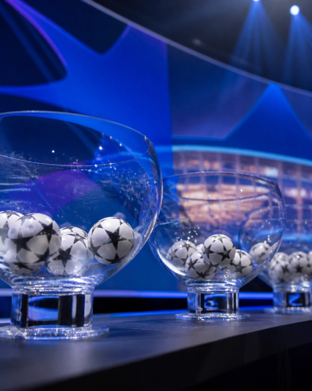 Neutrale gläserne Schalen mit Fußbällen vor einer blauen europäischen Stadionkulisse