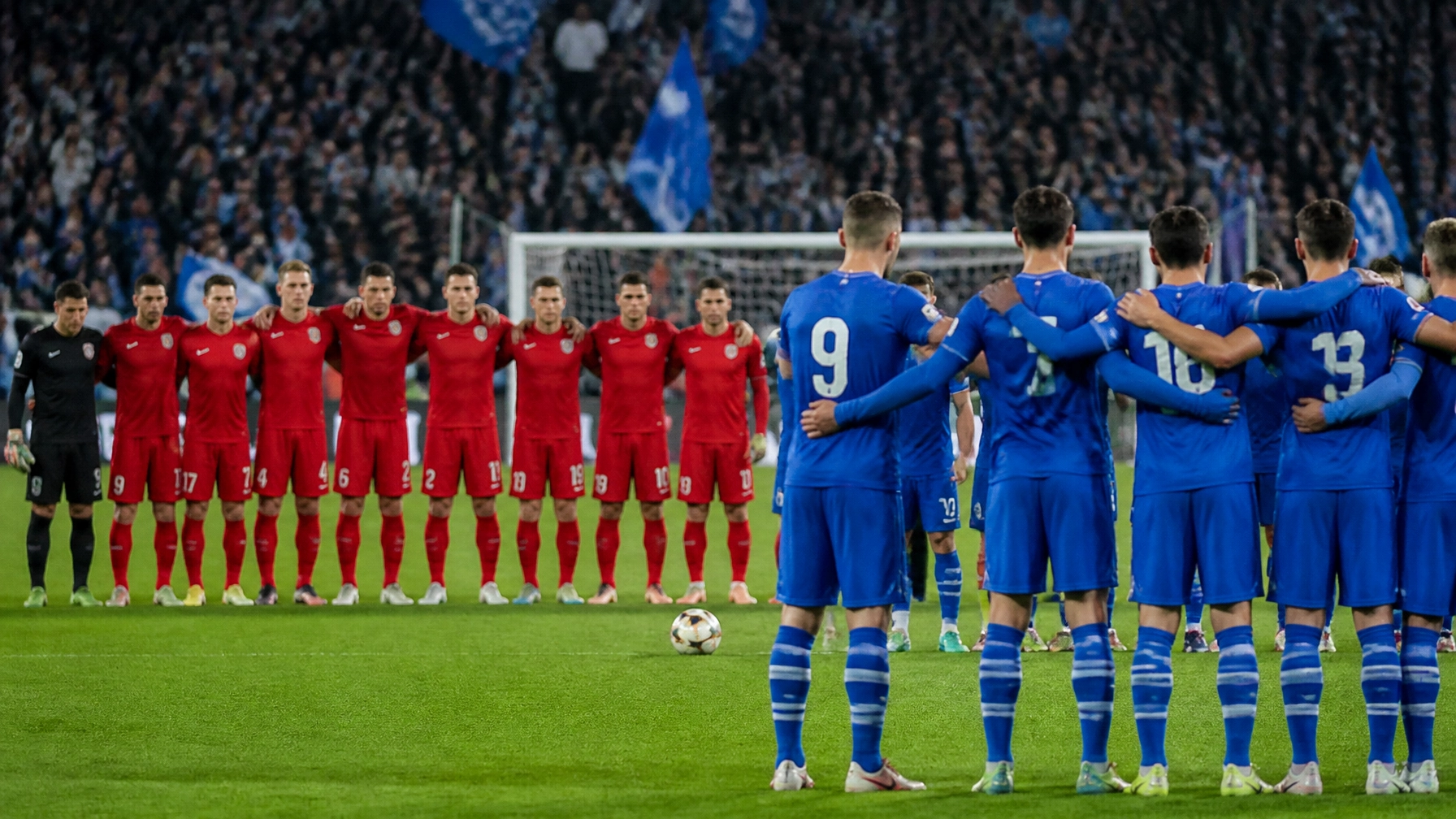 Tense football derby scene with generic red and blue kits and no branding