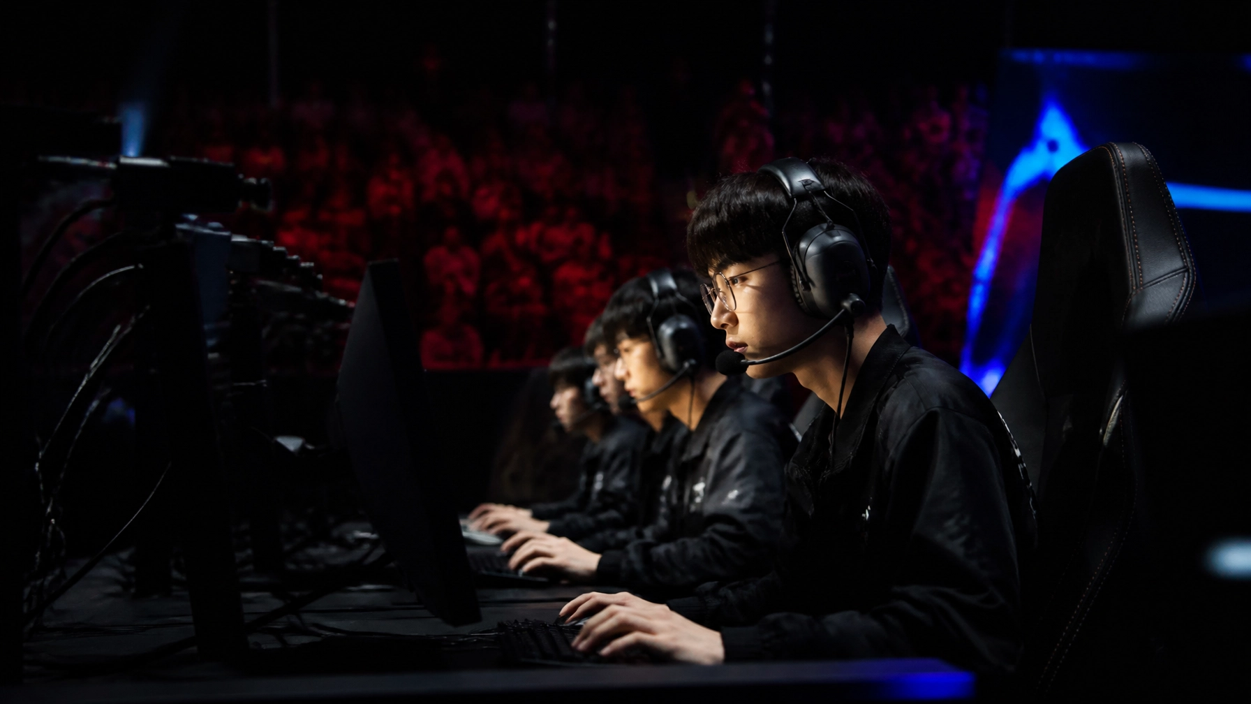 League-of-Legends-Playoffarena mit konzentrierten Profispielern