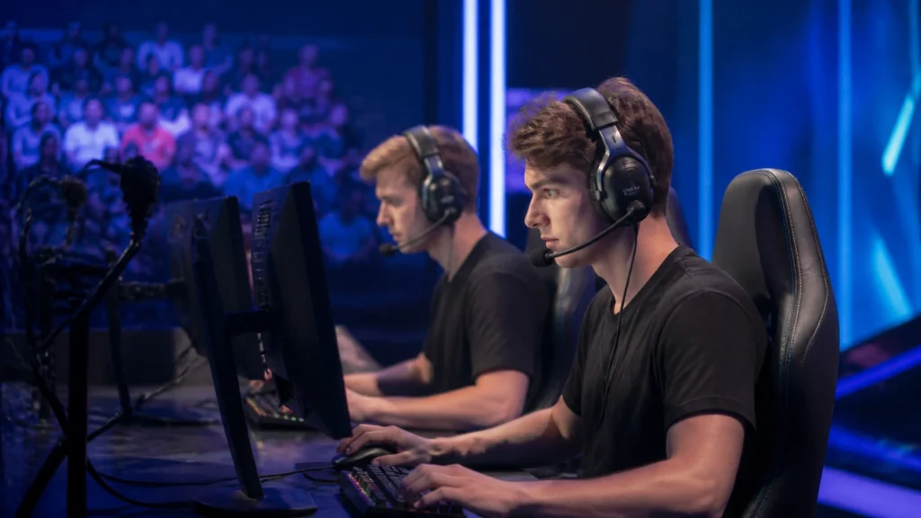 E-Sport-Spieler sitzen mit Headsets an ihren Computern