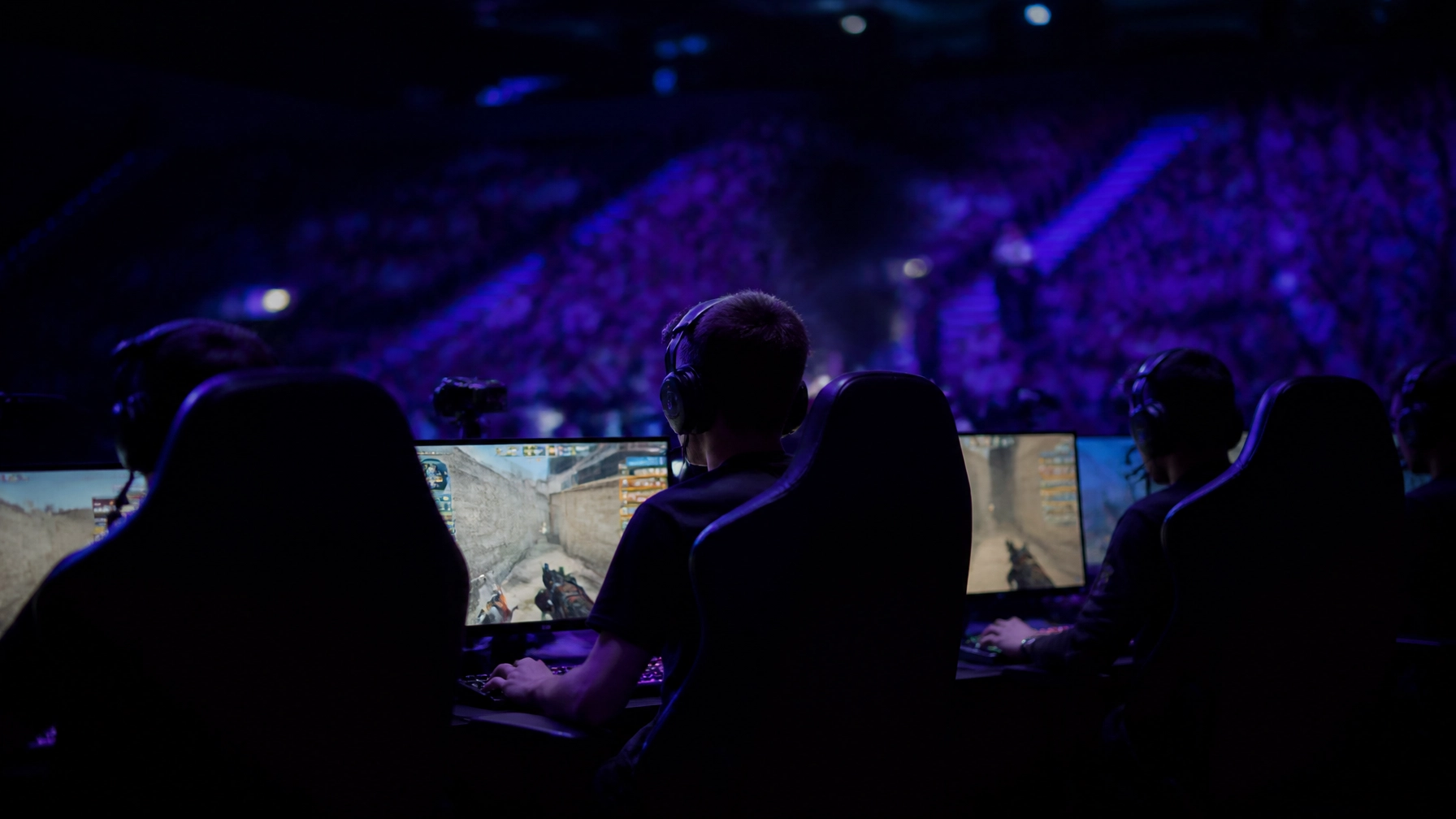 Professionelle E-Sports-Spieler in einer dunklen Turnierarena vor den BLAST-Open-Playoff-Entscheidungen