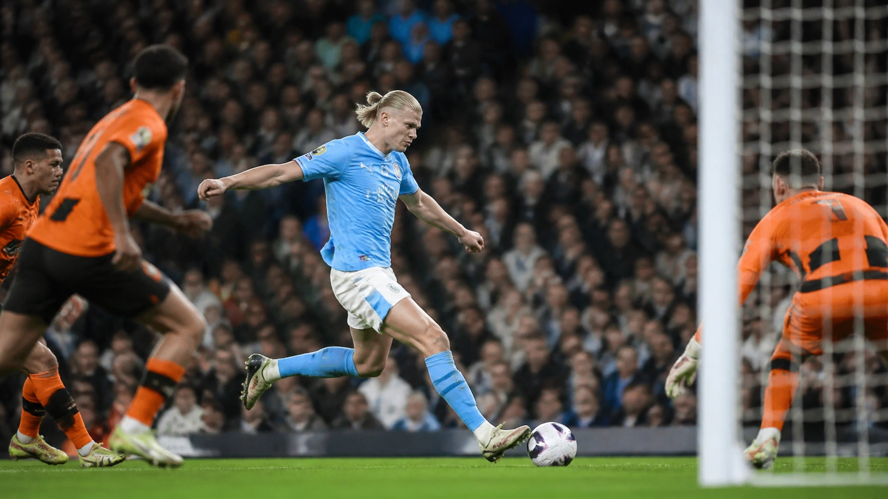 Stürmer im skyblauen Trikot vor dem Torabschluss im Stadion