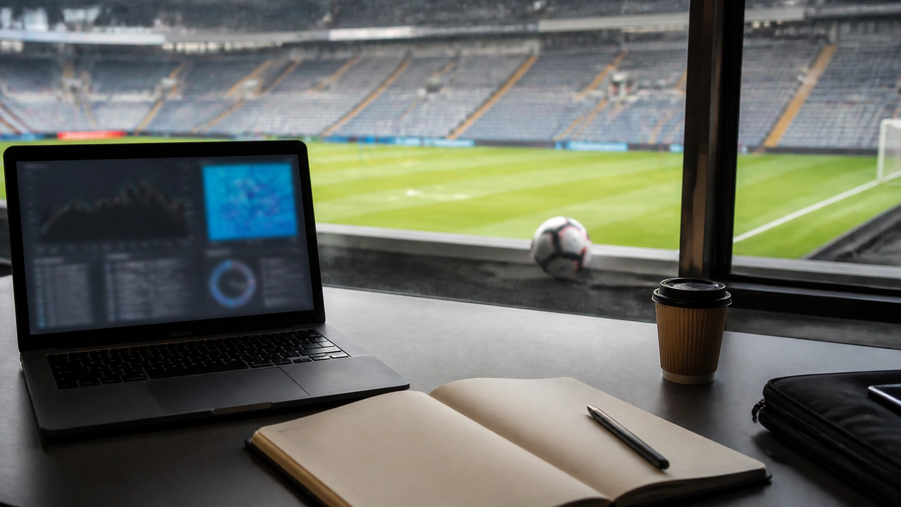Analytischer Arbeitsplatz mit Fußballplatz im Hintergrund