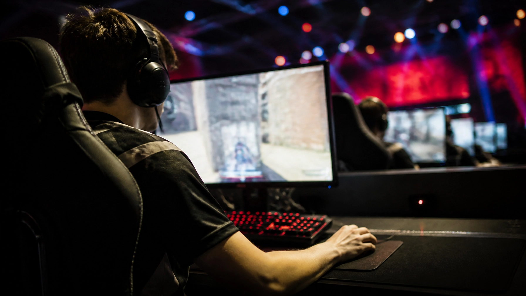 Fotorealistische E-Sports-Arena mit konzentriertem Spieler an einem PC