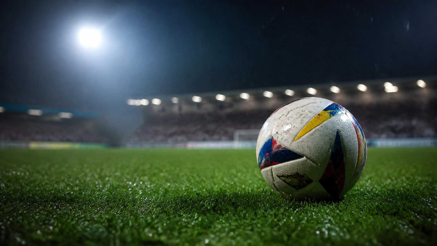 Fußball auf nassem Rasen unter Flutlicht vor einem Pokalspiel