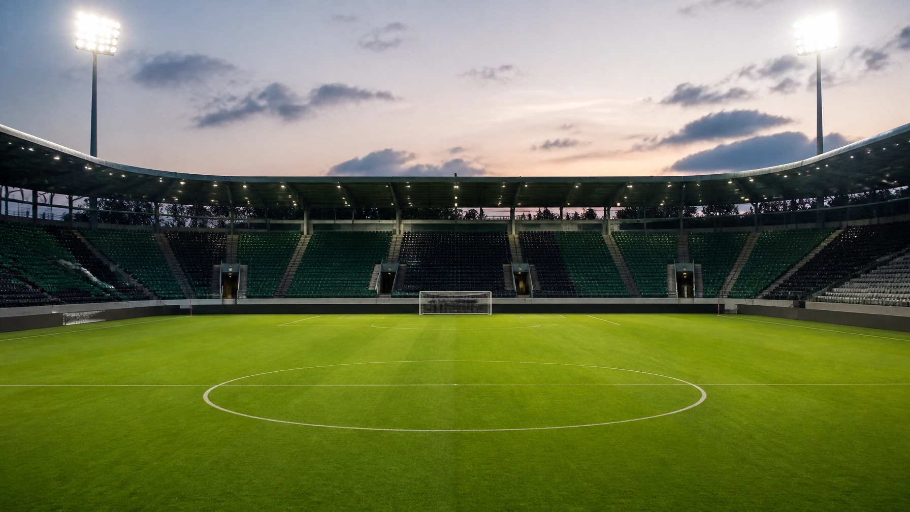 Leeres Fußballstadion vor dem Anpfiff mit Flutlicht und nassem Rasen