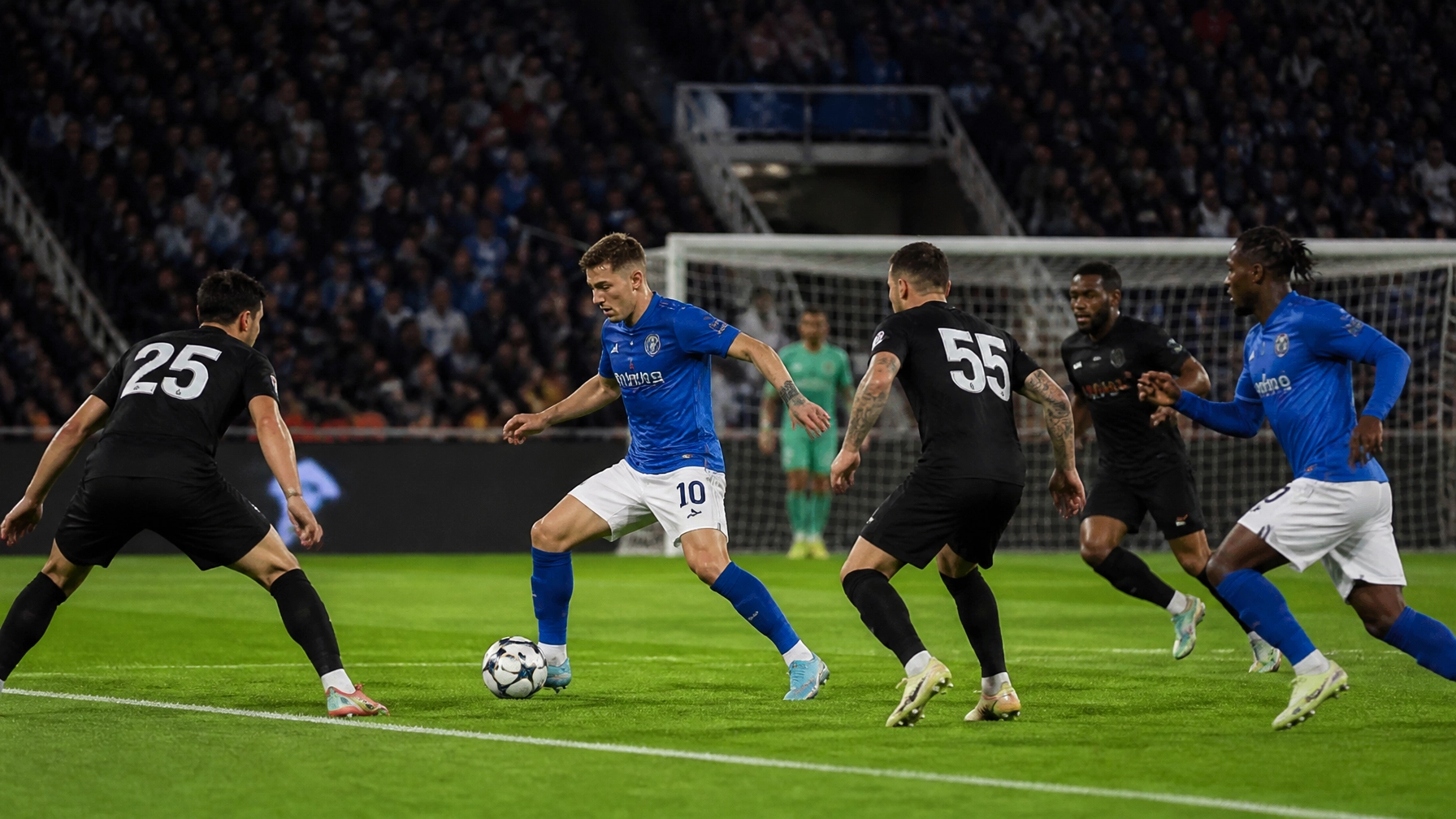 Dynamische Fußballszene mit Pressing nahe dem Strafraum unter Flutlicht