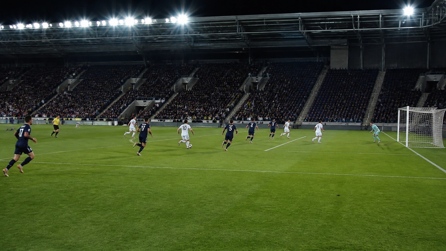 Dynamische Spielsituation im Strafraum eines unbrandeten Bundesliga-Stadions