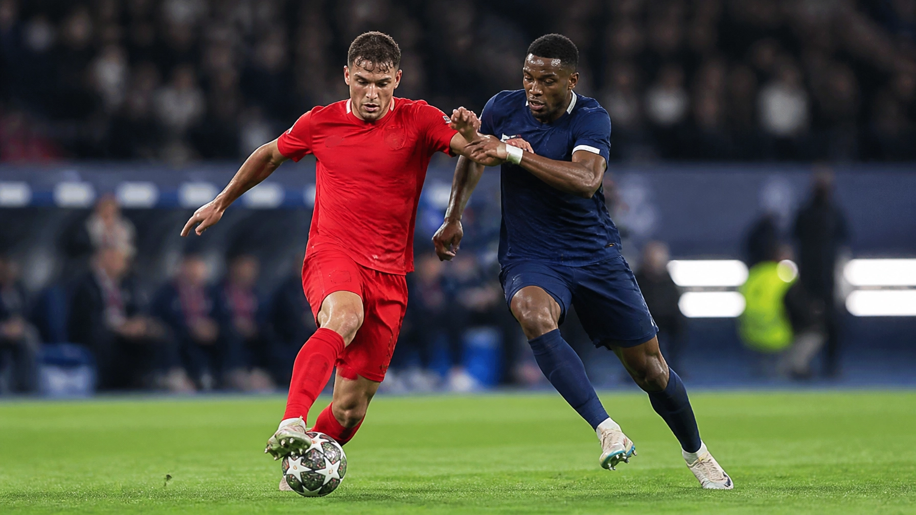 Zweikampf zwischen zwei Fußballspielern in einer internationalen Spielatmosphäre ohne Vereinslogos